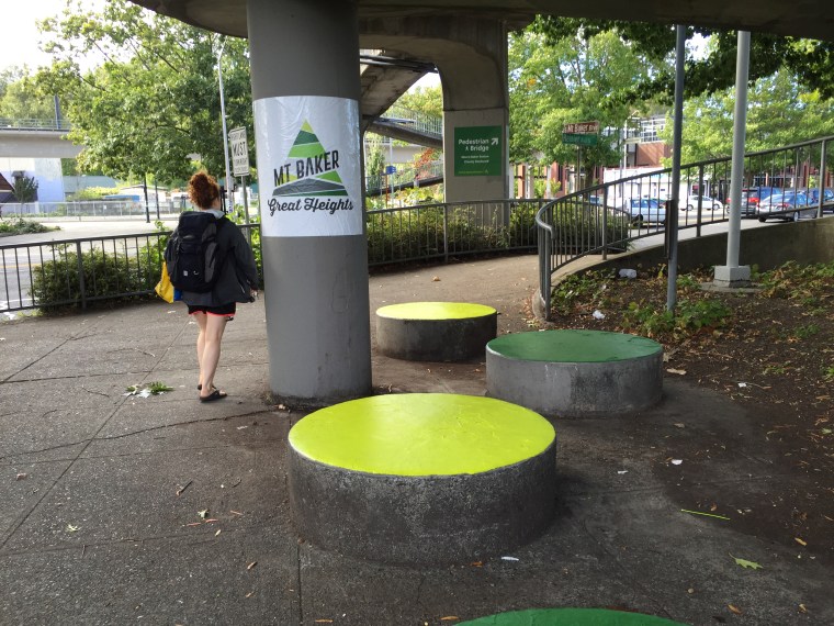 Woman walking through plaza area of pedestrian bridge